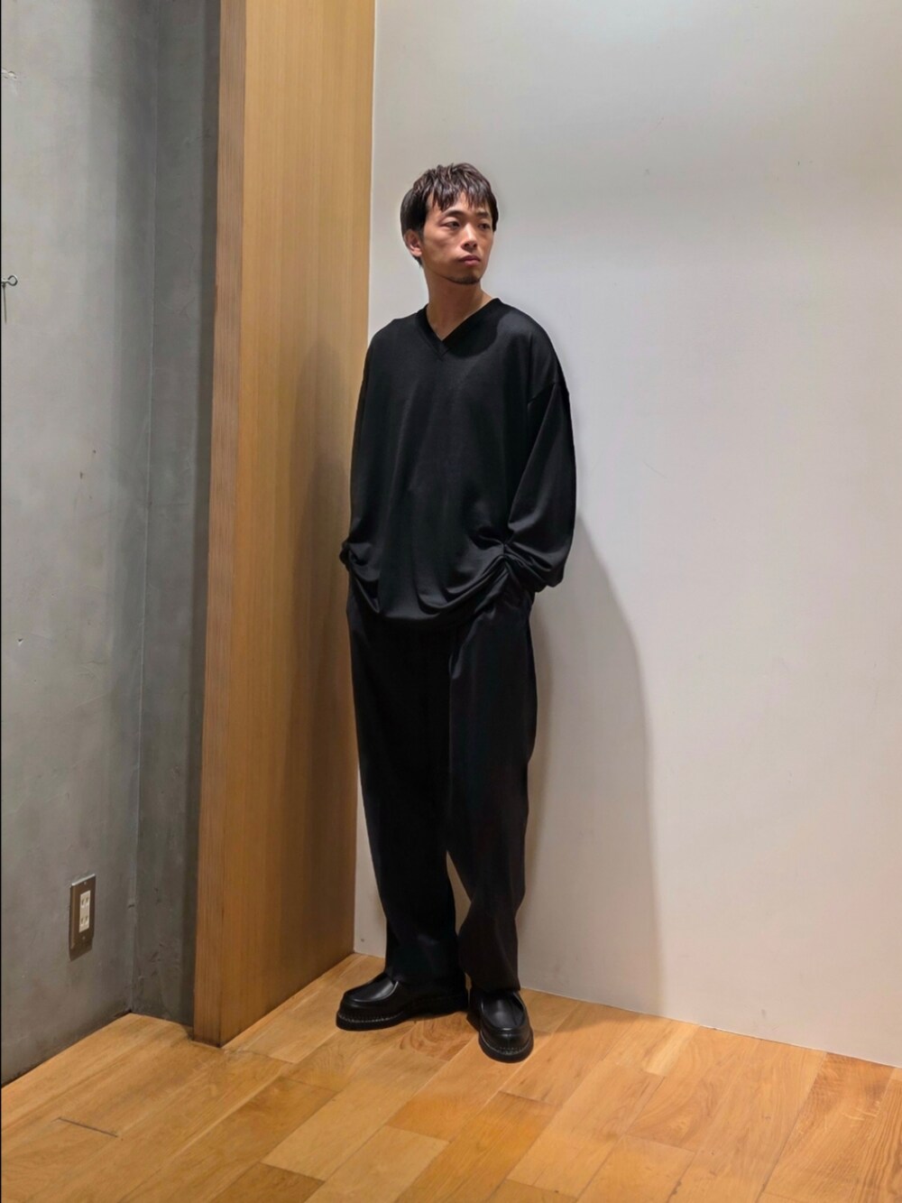 グリーン系のテーラードジャケット、ブラック系のニット/セーター、ブルー系のその他パンツを着用したメンズの秋コーディネートの5枚目の写真