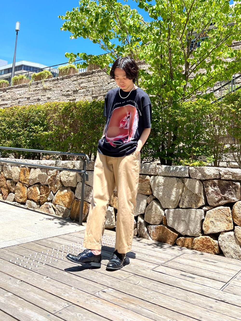 ブラック系のTシャツ/カットソー、ベージュ系のチノパンツ、ブラック系のドレスシューズを着用したメンズの夏コーディネートの2枚目の写真