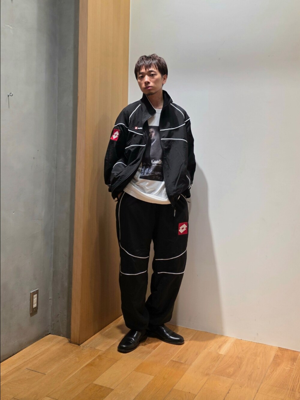 ブラック系のナイロンジャケット、ブラック系のその他パンツ、ホワイト系のTシャツ/カットソーを着用したメンズの秋コーディネートの2枚目の写真