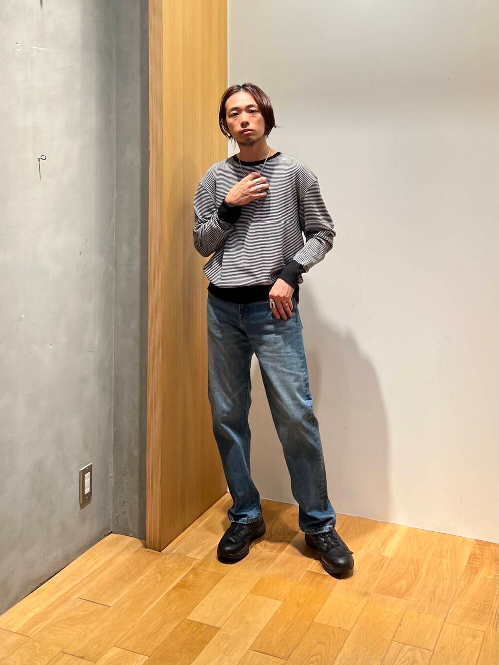 ホワイト系のニット/セーター、ブラック系のスニーカー、ブルー系のデニムパンツを着用したメンズの秋コーディネートの4枚目の写真