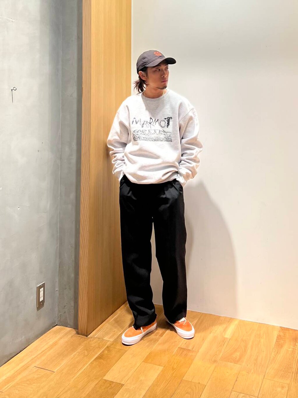 オレンジ系のスニーカー、ブラック系のスラックス、グレー系のスウェットを着用したメンズの秋コーディネートの5枚目の写真