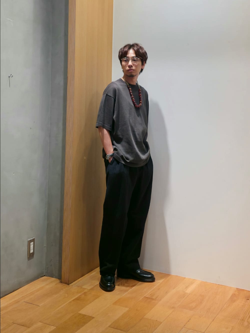 グレー系のニット/セーター、ブルー系のその他パンツ、ブラック系のドレスシューズを着用したメンズの夏コーディネートの3枚目の写真