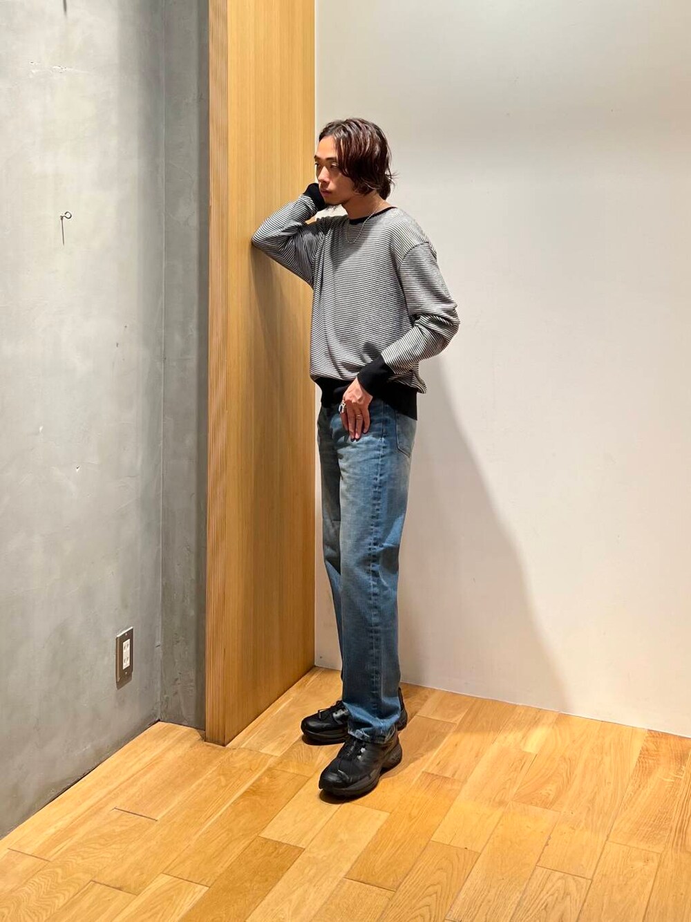 ホワイト系のニット/セーター、ブラック系のスニーカー、ブルー系のデニムパンツを着用したメンズの秋コーディネートの3枚目の写真