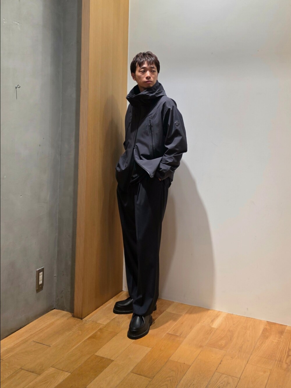 グリーン系のテーラードジャケット、ブラック系のニット/セーター、ブルー系のその他パンツを着用したメンズの秋コーディネートの2枚目の写真