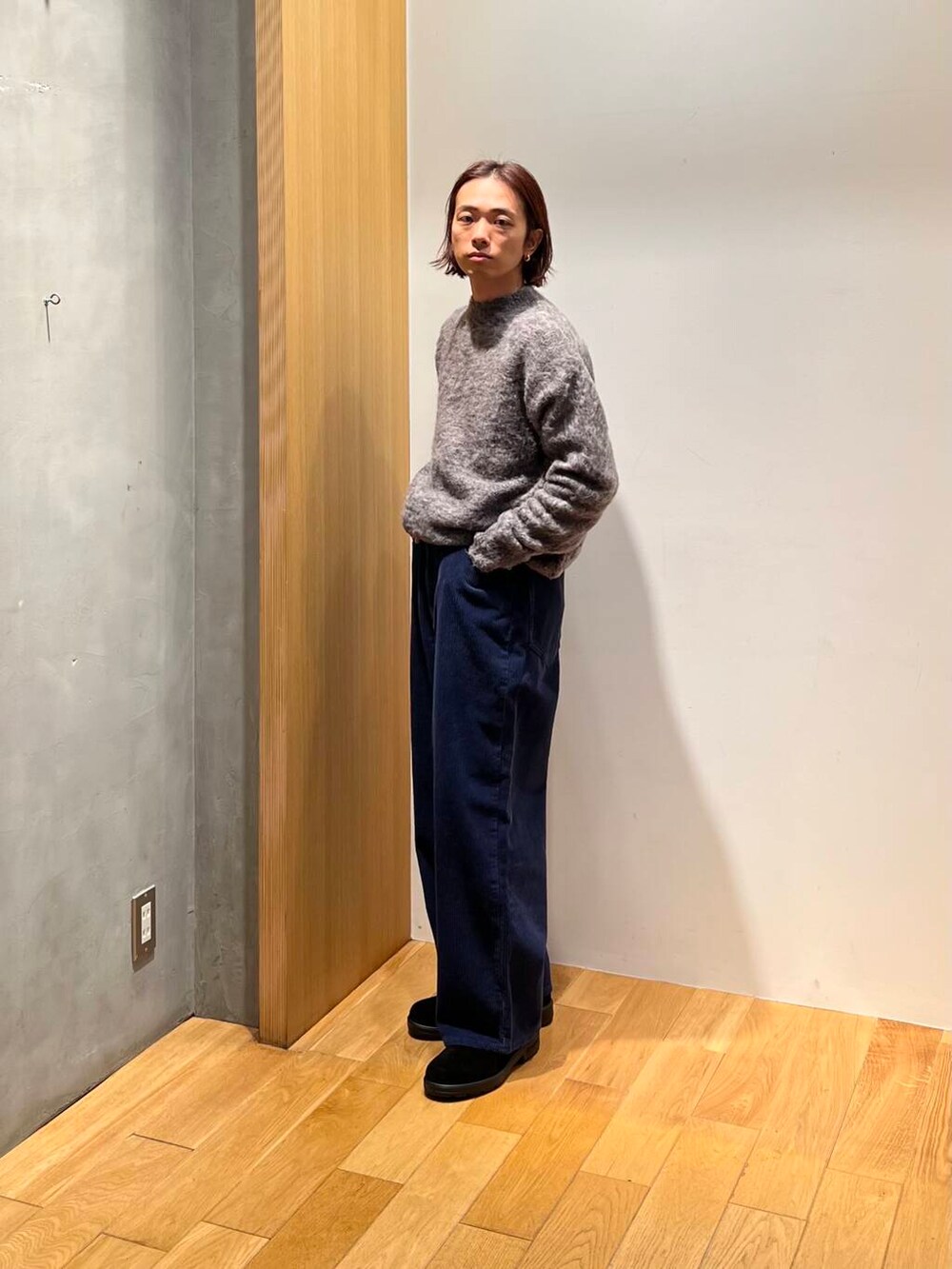 ブラウン系のステンカラーコート、ブルー系のその他パンツ、グレー系のニット/セーターを着用したメンズの冬コーディネートの6枚目の写真