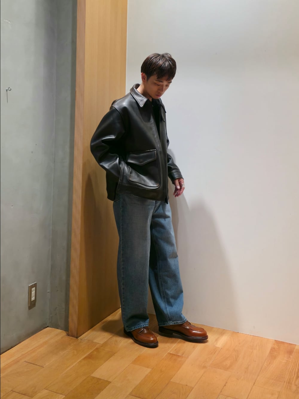 ブラウン系のその他アウター、ブラック系のTシャツ/カットソー、ブルー系のデニムパンツを着用したメンズの秋コーディネートの2枚目の写真