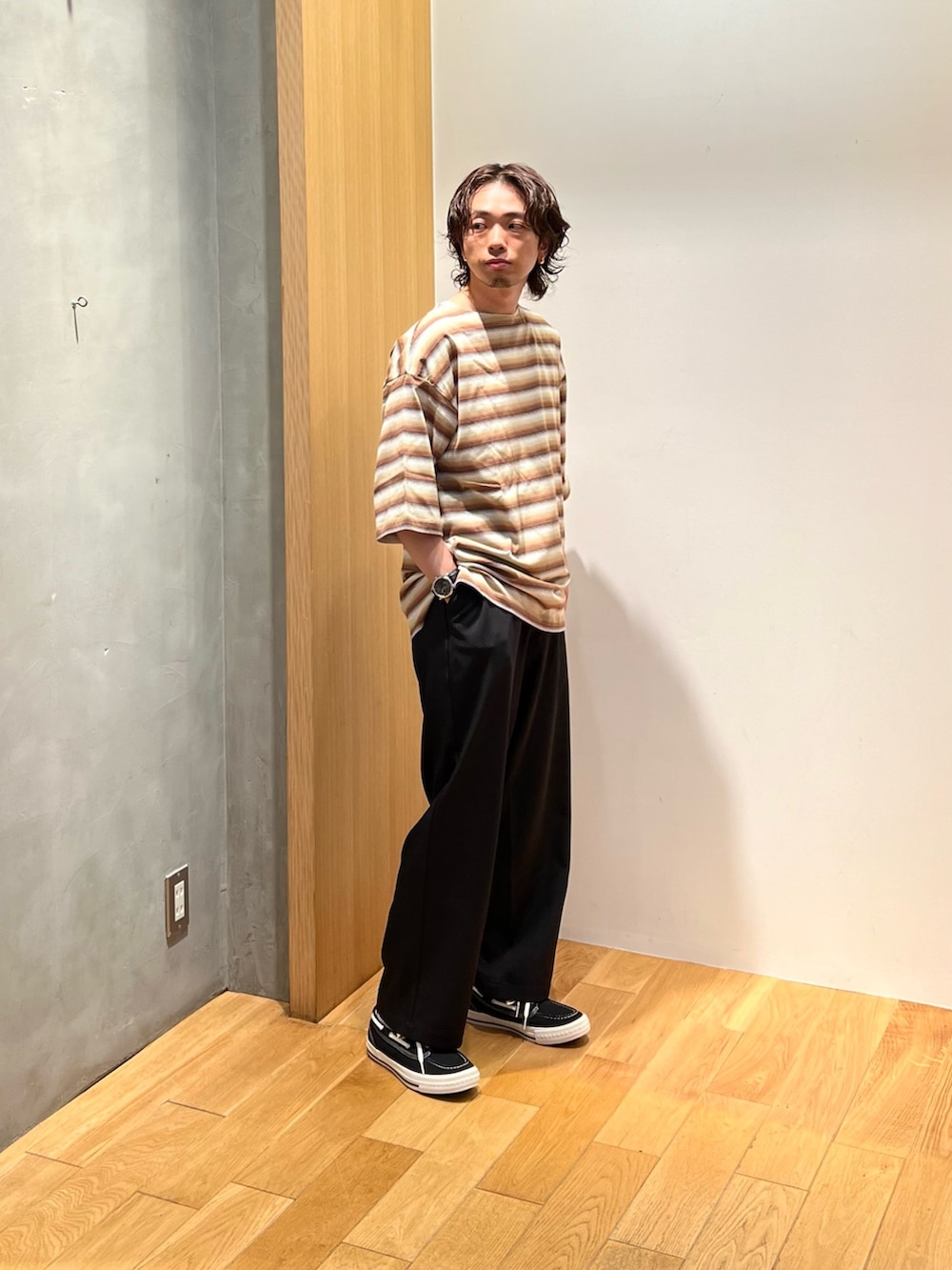 ブラウン系のTシャツ/カットソー、ブラック系のチノパンツ、ブラック系のスニーカーを着用したメンズの夏コーディネートの3枚目の写真
