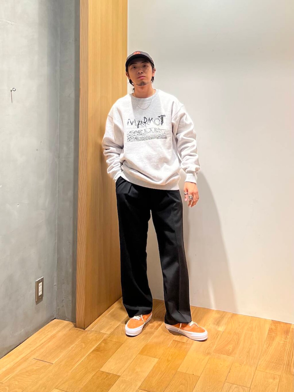 オレンジ系のスニーカー、ブラック系のスラックス、グレー系のスウェットを着用したメンズの秋コーディネートの2枚目の写真