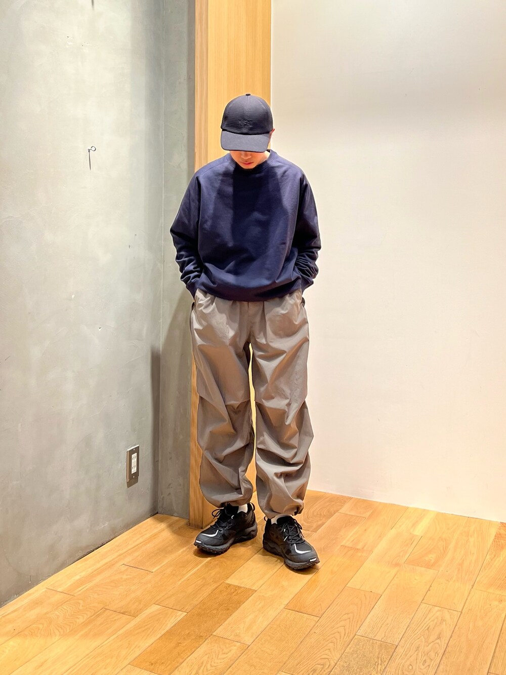 ブルー系のスウェット、グリーン系のその他パンツ、ブラック系のスニーカーを着用したメンズの冬コーディネートの2枚目の写真