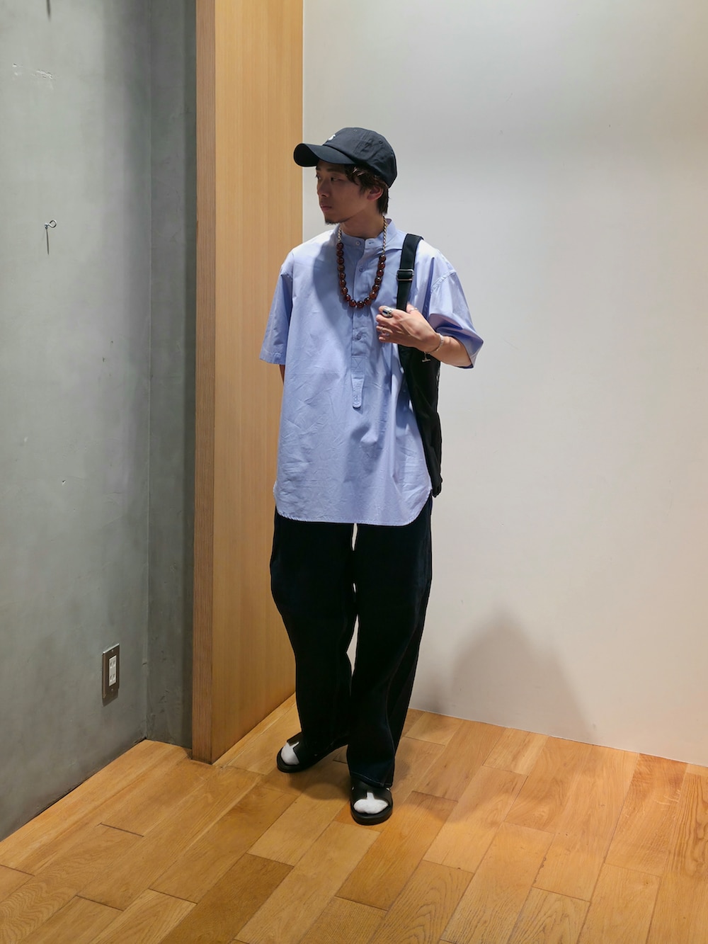 ブルー系のシャツ/ブラウス、ブラック系のショルダーバッグ、ブラック系のキャップを着用したメンズの夏コーディネートの2枚目の写真