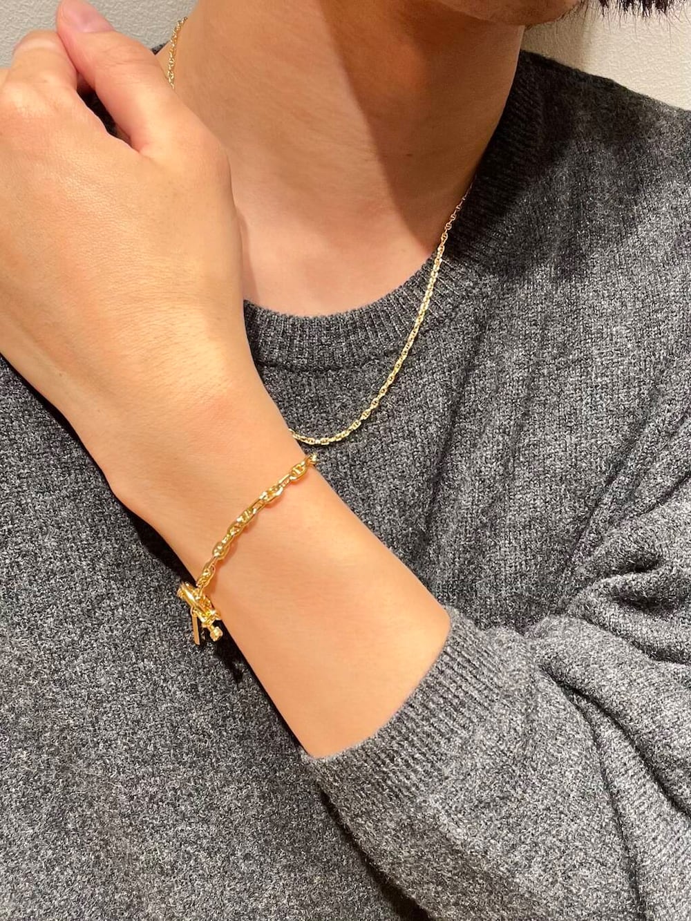 グレー系のニット/セーター、ゴールド系のネックレス、ゴールド系のネックレスを着用したメンズの秋コーディネートの3枚目の写真