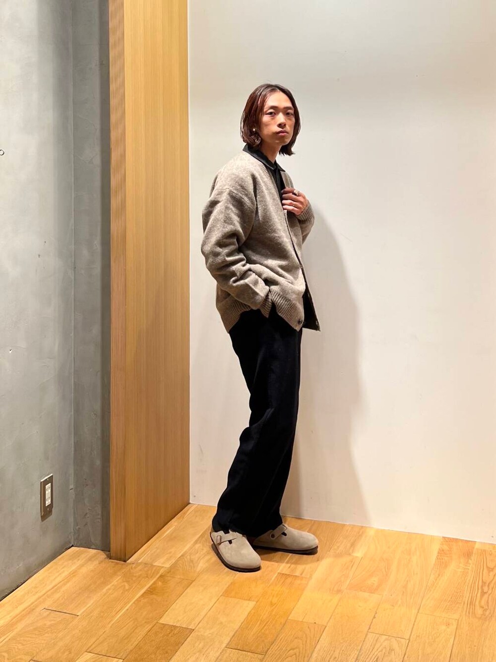 ブラック系のスラックス、グレー系のシャツ/ブラウス、ブラウン系のカーディガン/ボレロを着用したメンズの秋コーディネートの5枚目の写真