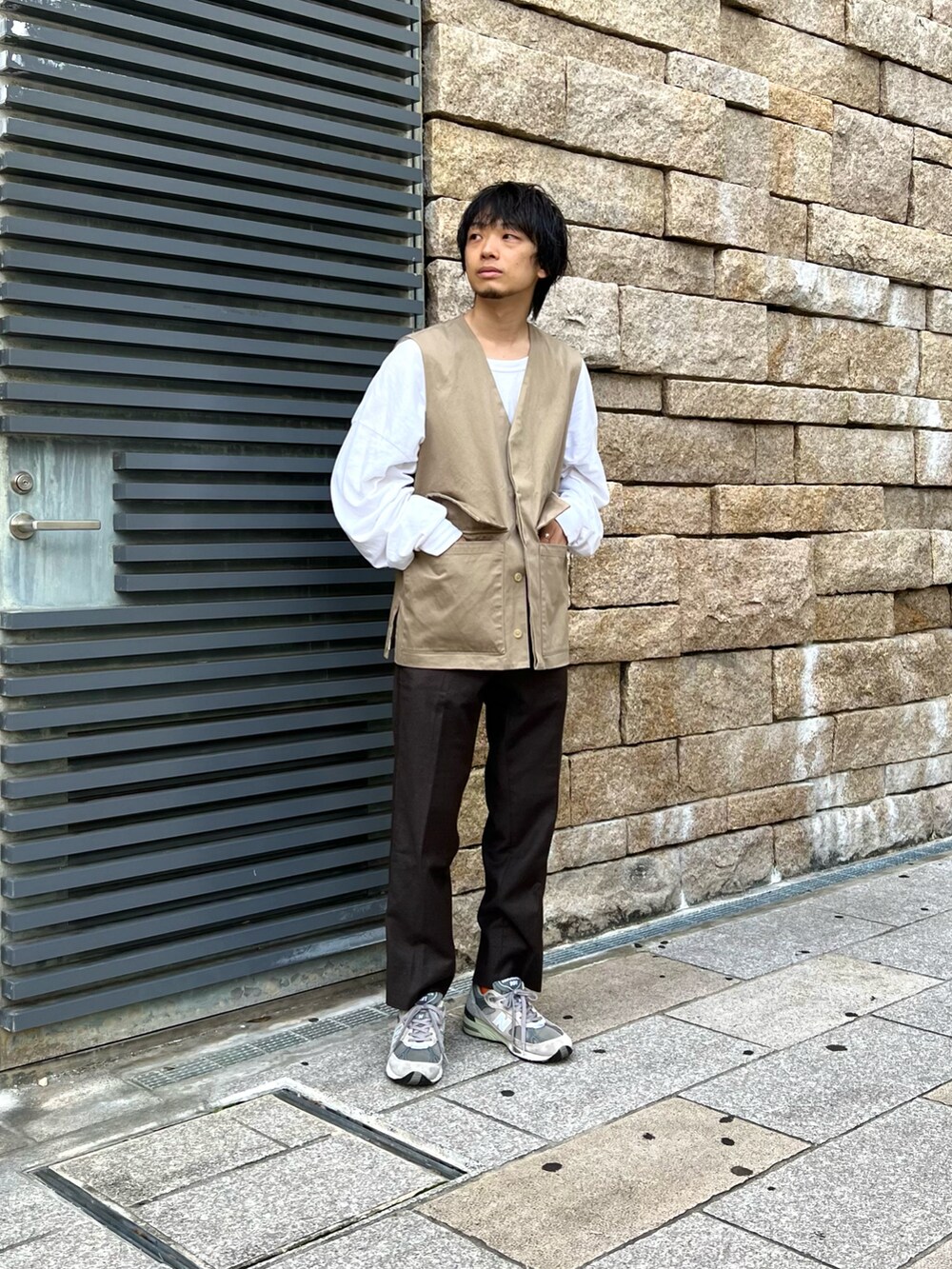 ベージュ系のベスト、ホワイト系のTシャツ/カットソー、ブラウン系のパンツを着用したメンズの夏コーディネートの2枚目の写真