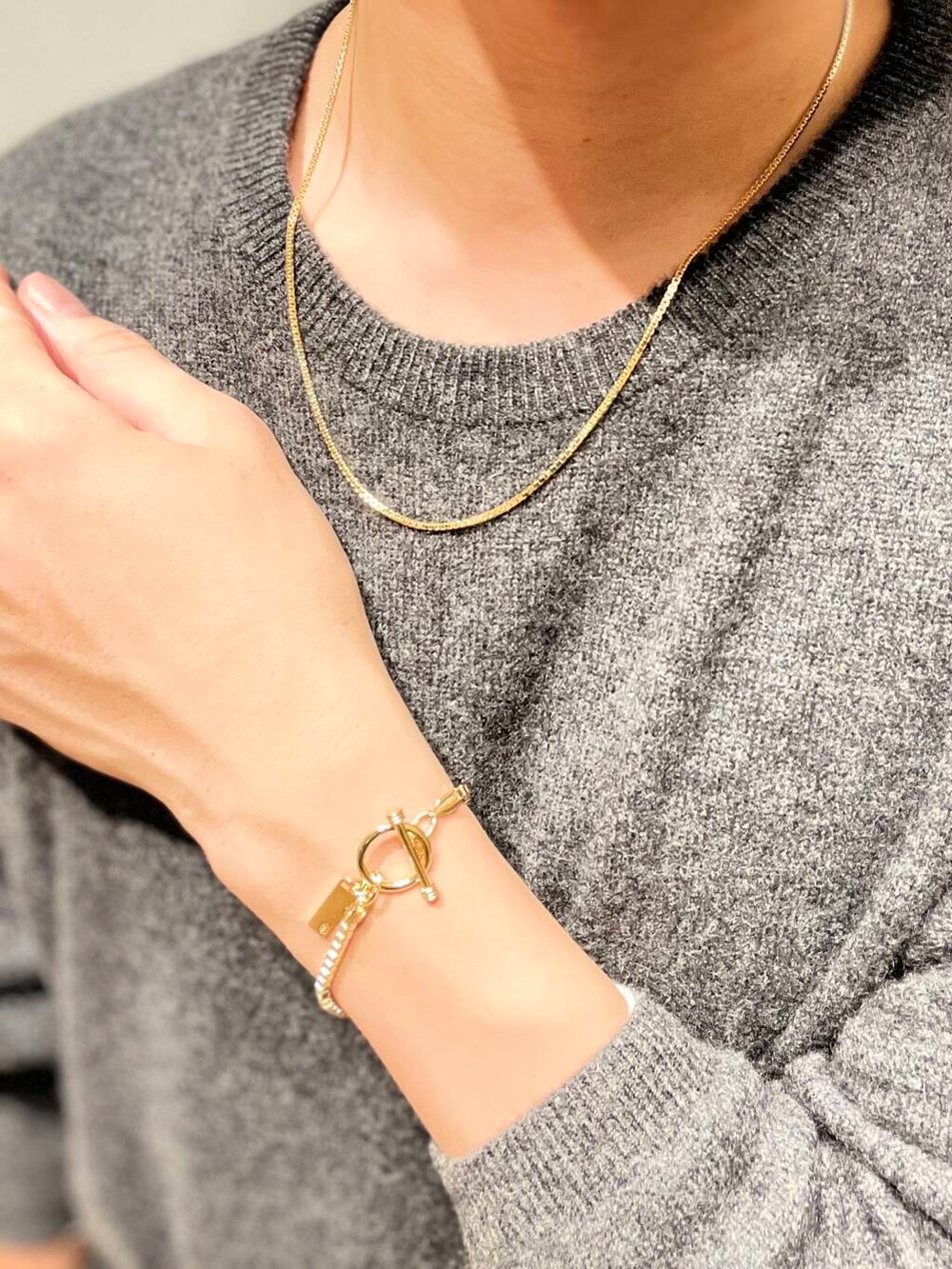 グレー系のニット/セーター、ゴールド系のネックレス、ゴールド系のネックレスを着用したメンズの秋コーディネートの2枚目の写真