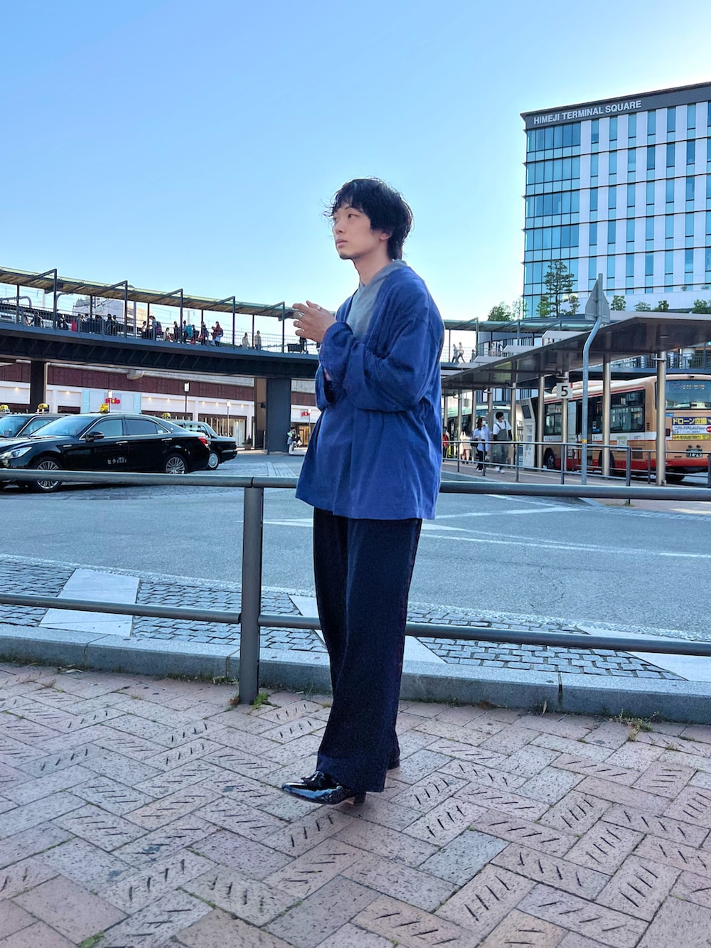 ブルー系のトップス、グレー系のベスト、ブルー系のその他パンツを着用したメンズの春コーディネートの2枚目の写真