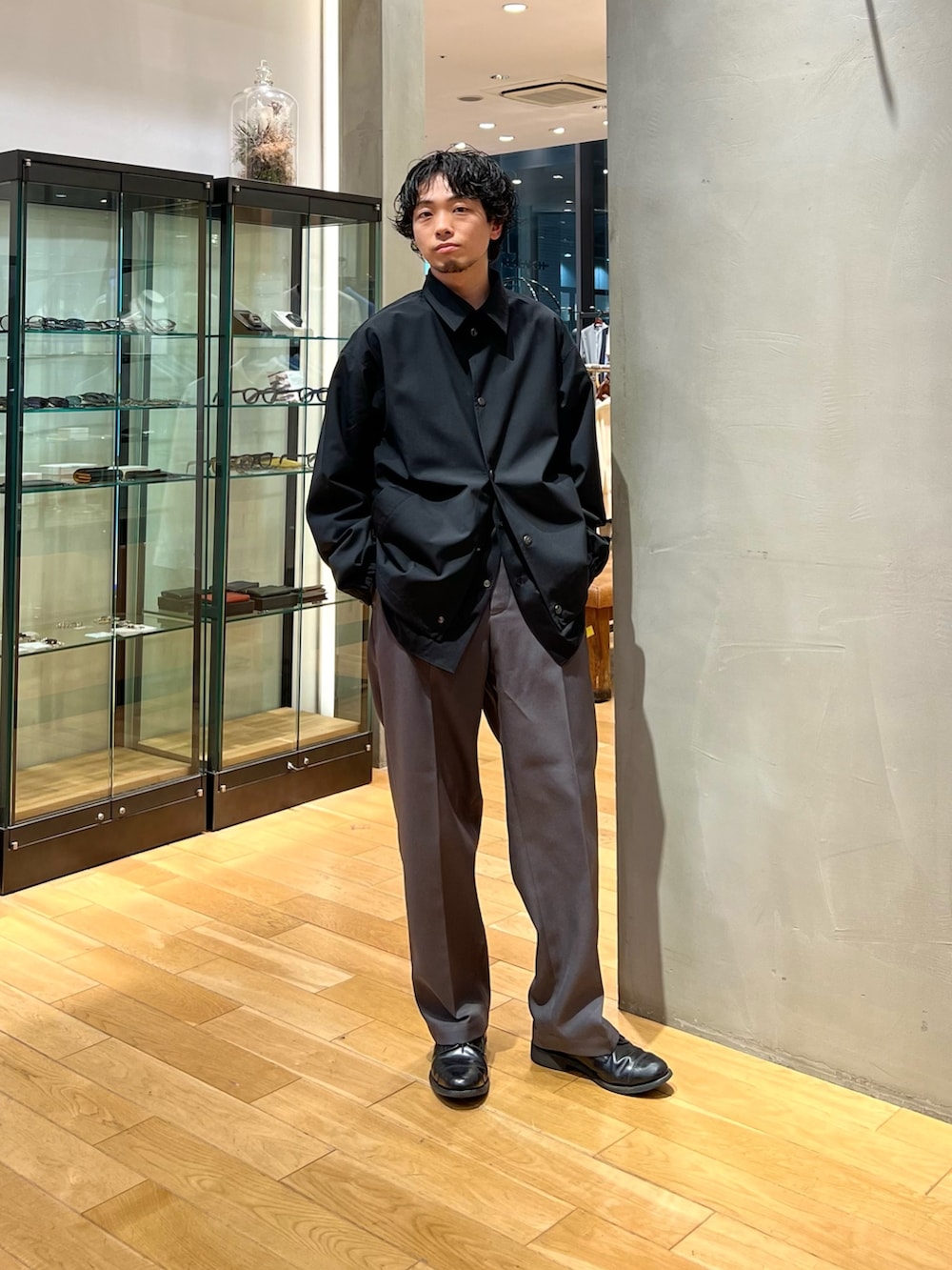 ブラック系のその他アウター、ブラック系のシャツ/ブラウス、グレー系のスラックスを着用したメンズの春コーディネートの4枚目の写真