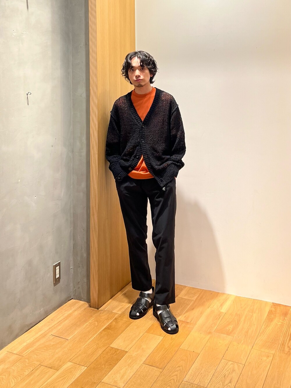オレンジ系のTシャツ/カットソー、ブラック系のその他パンツ、ブラック系のサンダルを着用したメンズの春コーディネートの4枚目の写真