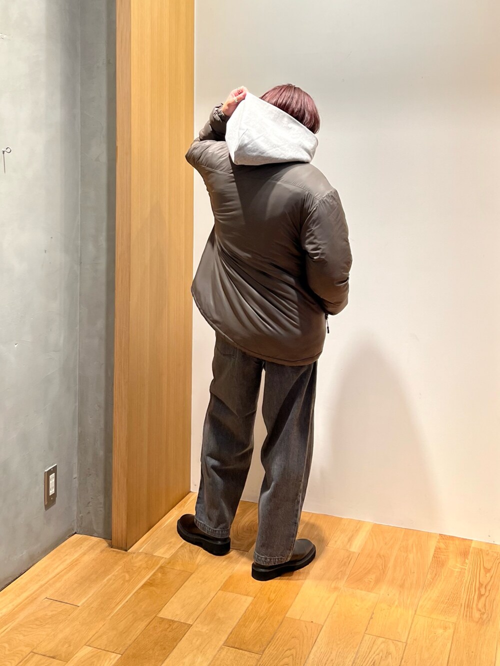 グリーン系のブルゾン、グレー系のパーカー、グレー系のデニムパンツを着用したメンズの秋コーディネートの2枚目の写真