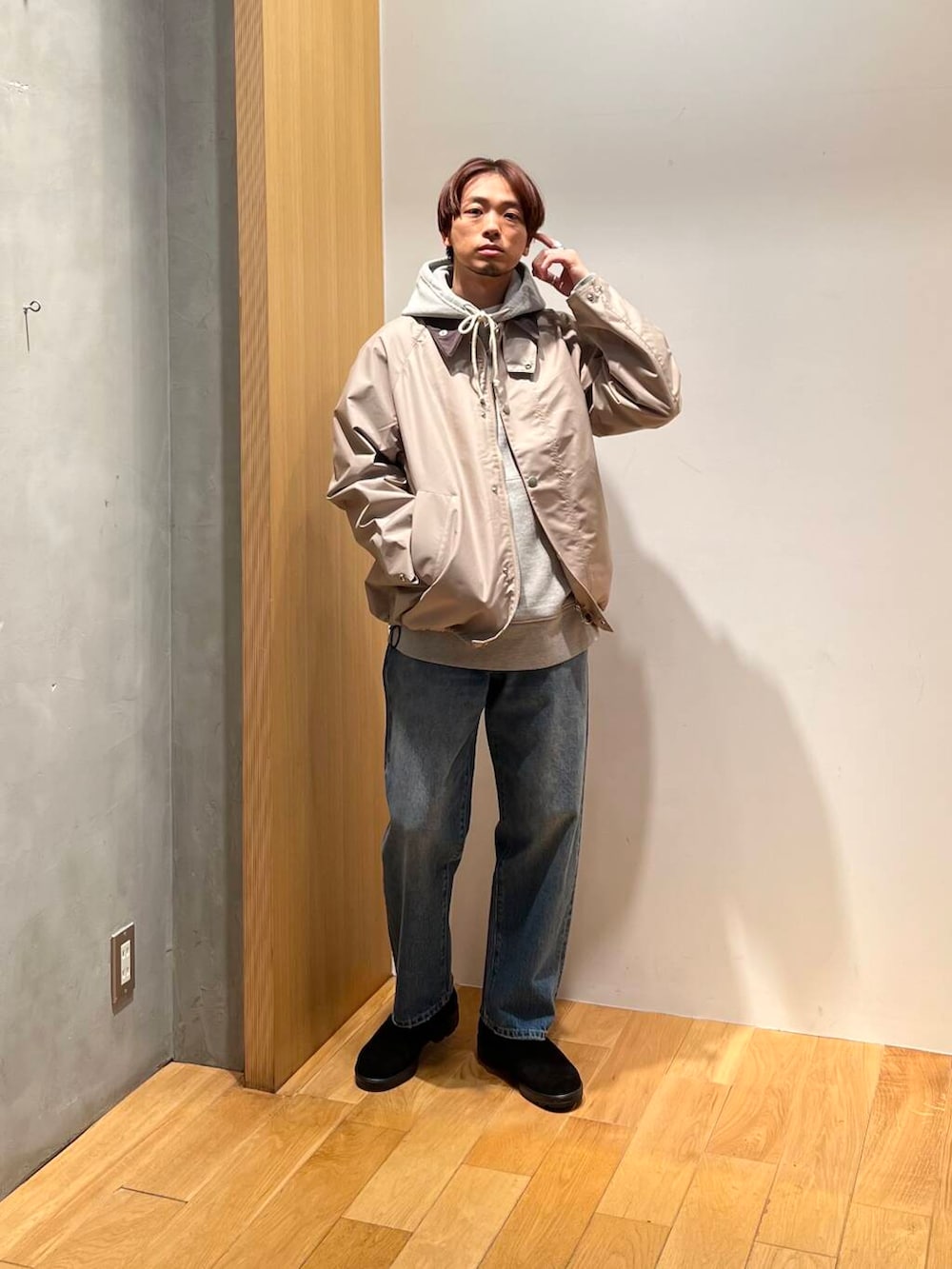 ブラック系のブーツ、ブルー系のデニムパンツ、ベージュ系のナイロンジャケットを着用したメンズの冬コーディネートの4枚目の写真
