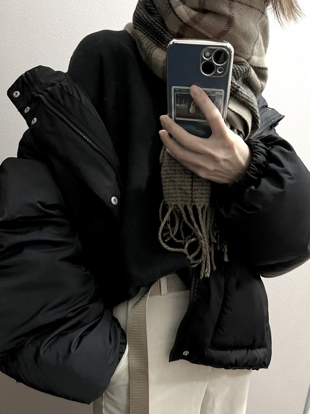 ブラック系のダウンジャケット/コート、ベージュ系のベルトを着用したレディースの冬コーディネートの2枚目の写真