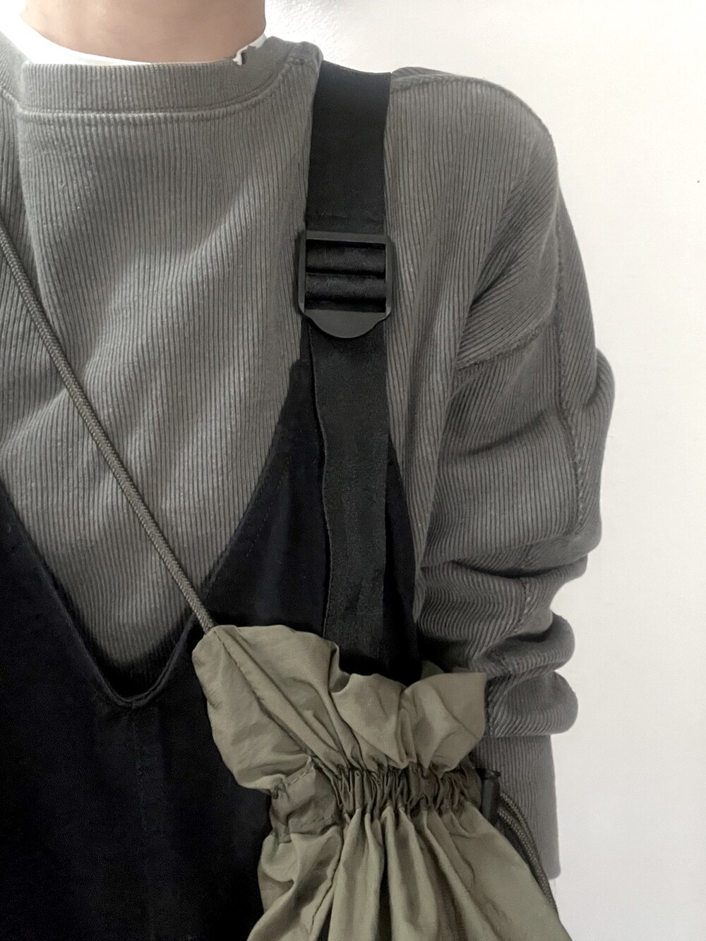 グレー系のスウェット、グリーン系のショルダーバッグを着用したレディースの冬コーディネートの3枚目の写真