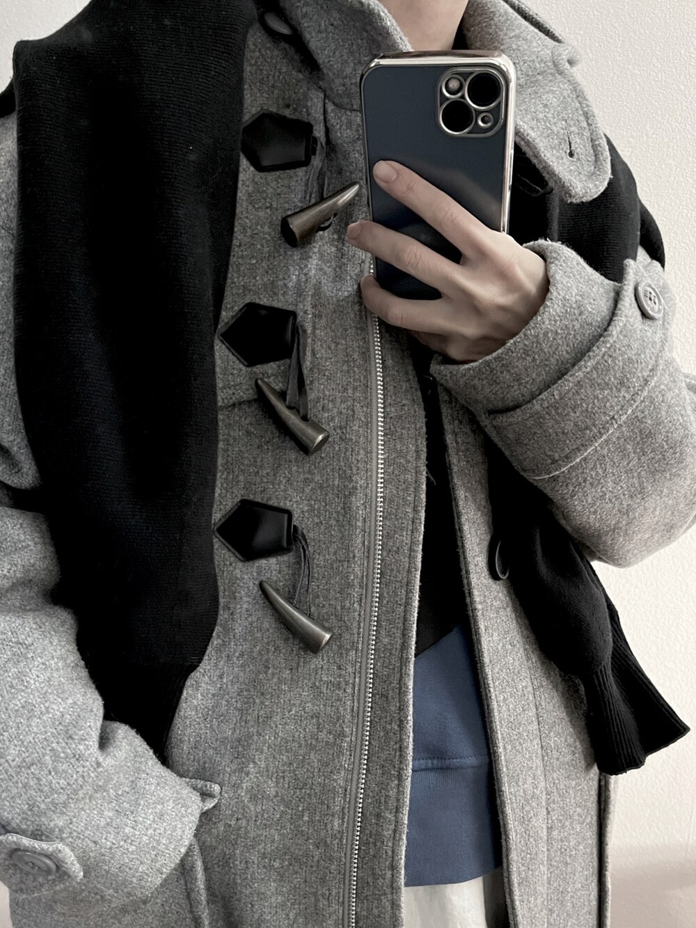グレー系のダッフルコートを着用したレディースの冬コーディネートの4枚目の写真