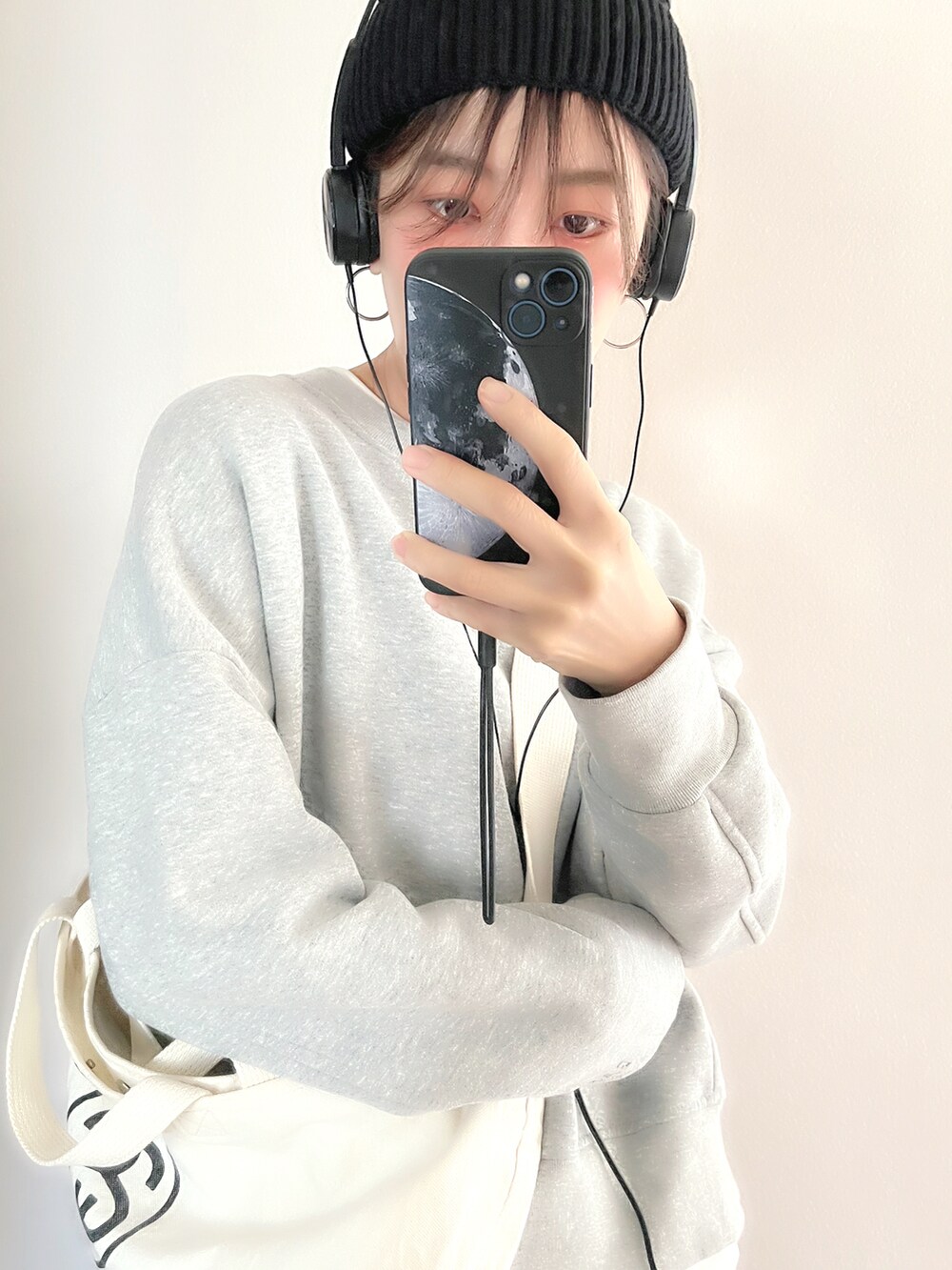 グレー系のスウェット、ホワイト系のショルダーバッグを着用したレディースの春コーディネートの2枚目の写真