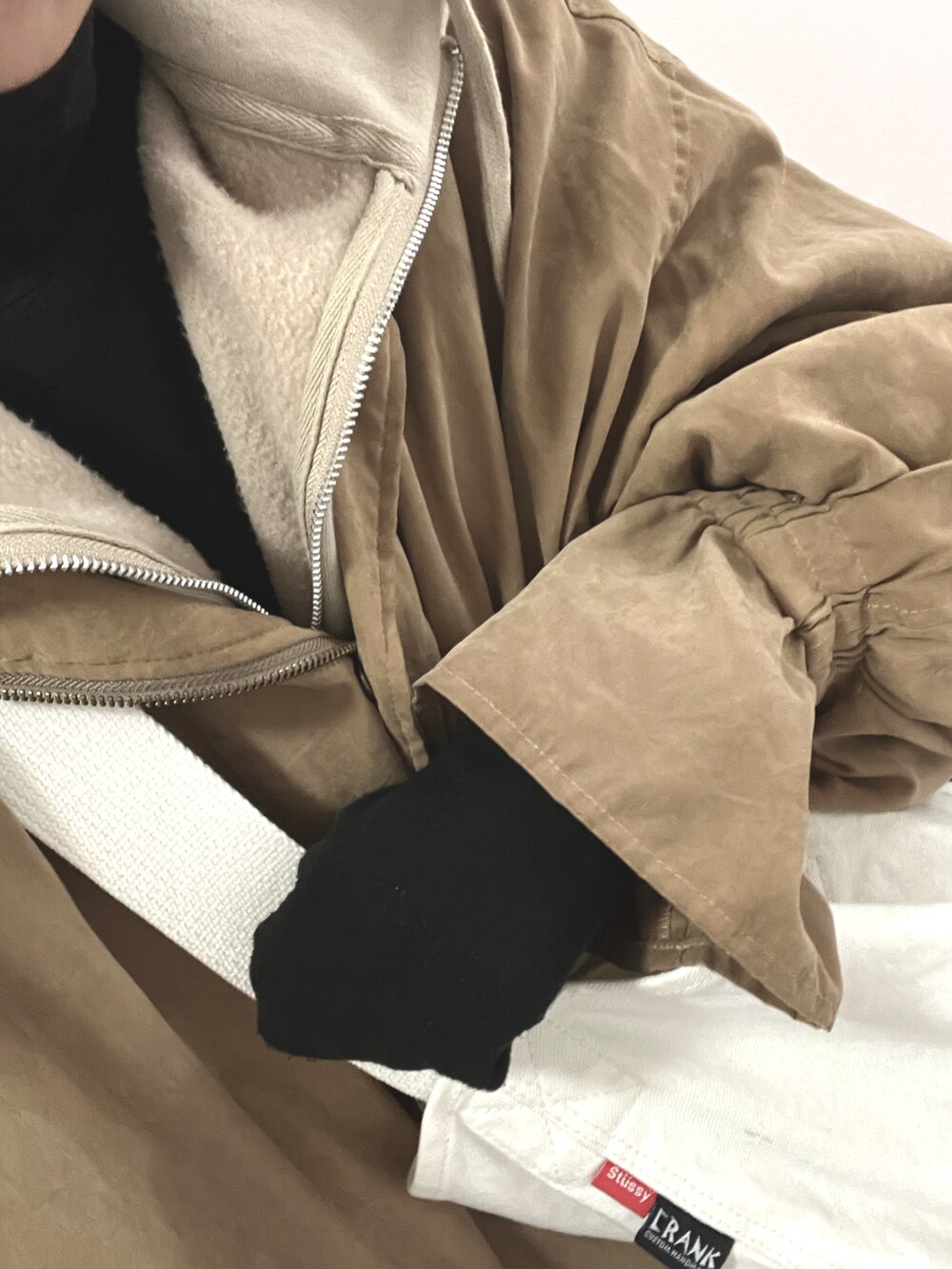 ベージュ系のパーカー、ベージュ系のブルゾンを着用したレディースの冬コーディネートの3枚目の写真