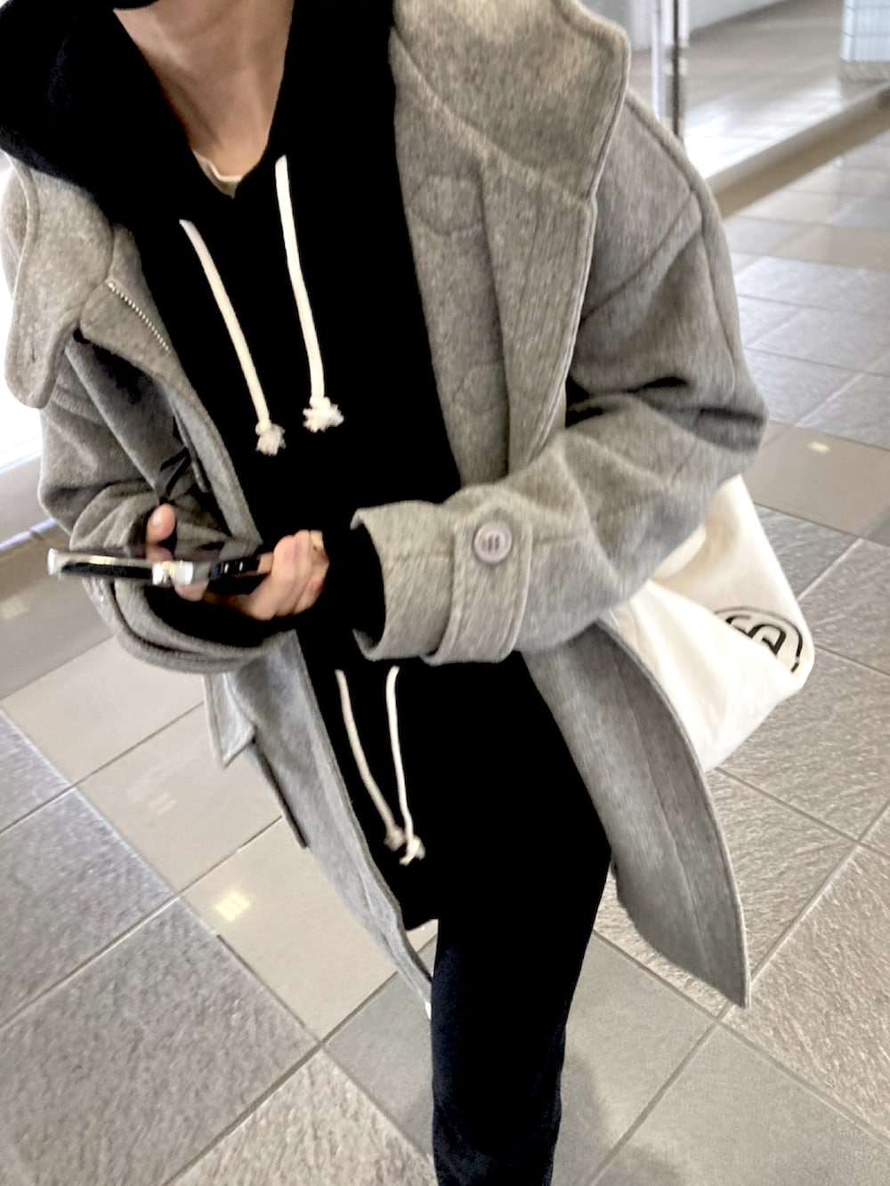 ブラック系のスウェットパンツ、ブラック系のパーカー、ブラック系のスニーカーを着用したレディースの冬コーディネートの2枚目の写真