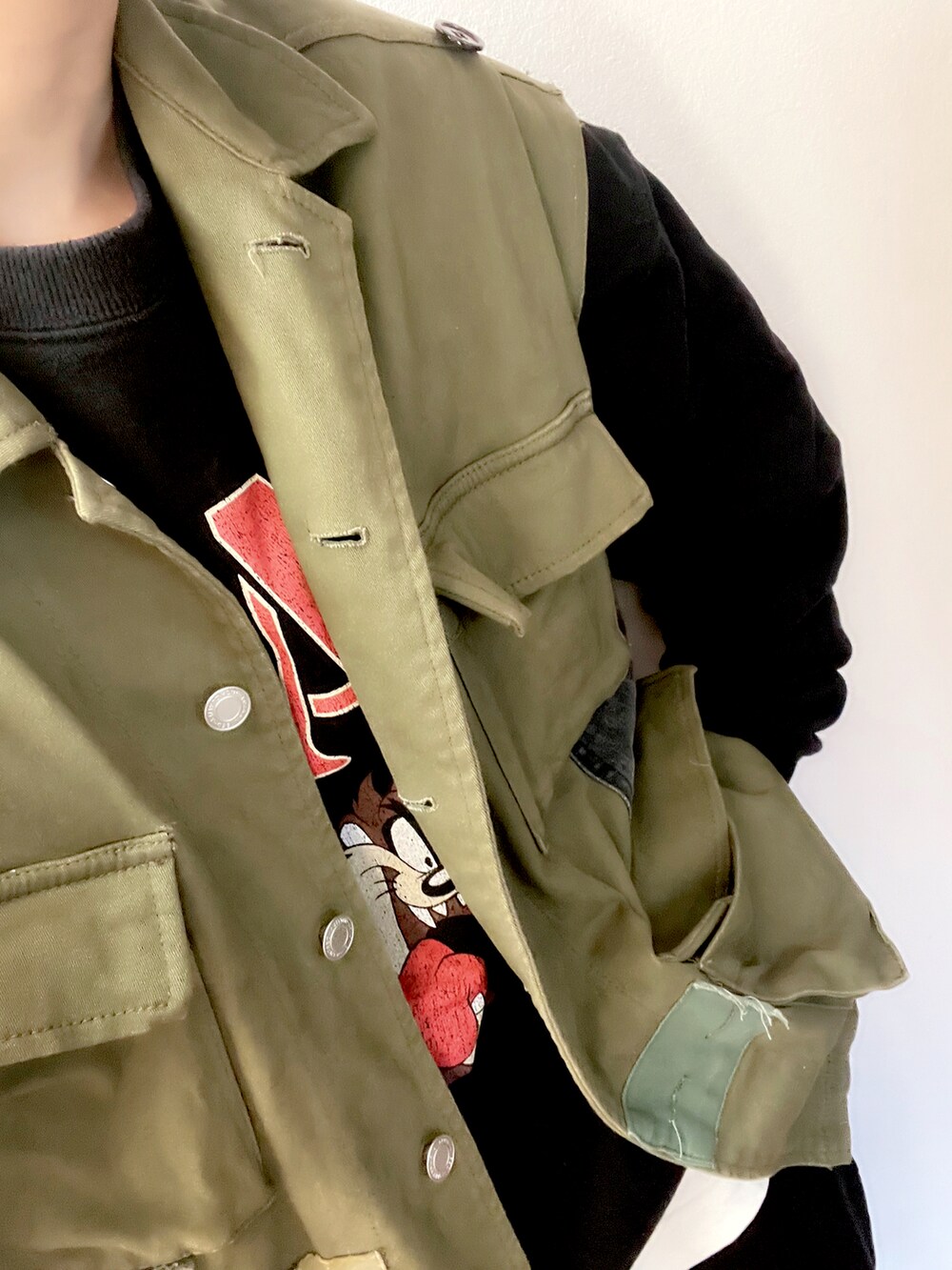 グリーン系のベスト、ブラック系のスウェットを着用したレディースの春コーディネートの2枚目の写真