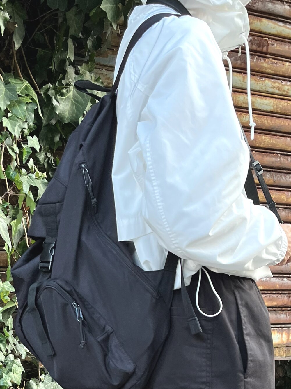 ホワイト系のスニーカー、ブラック系のカーゴパンツを着用したレディースの春コーディネートの2枚目の写真