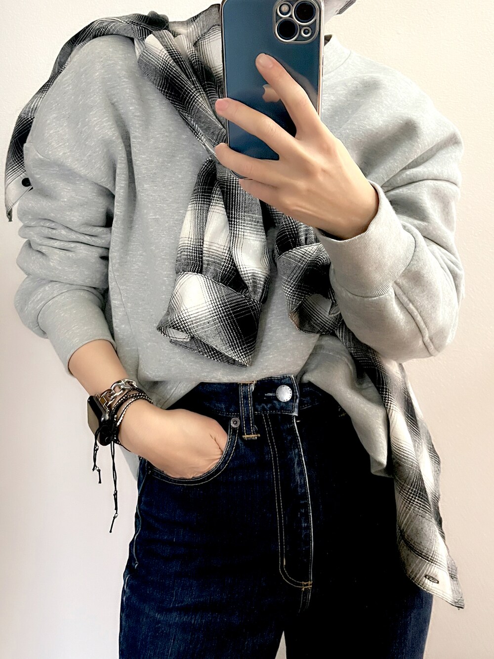 ブルー系のデニムパンツ、グレー系のスウェット、ブルー系のキャップを着用したレディースの春コーディネートの2枚目の写真