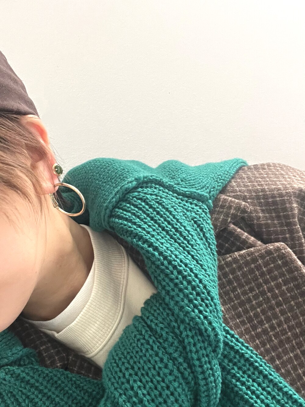 ブラウン系のピーコート、グリーン系のニット/セーター、ブラウン系のキャップを着用したレディースの冬コーディネートの3枚目の写真