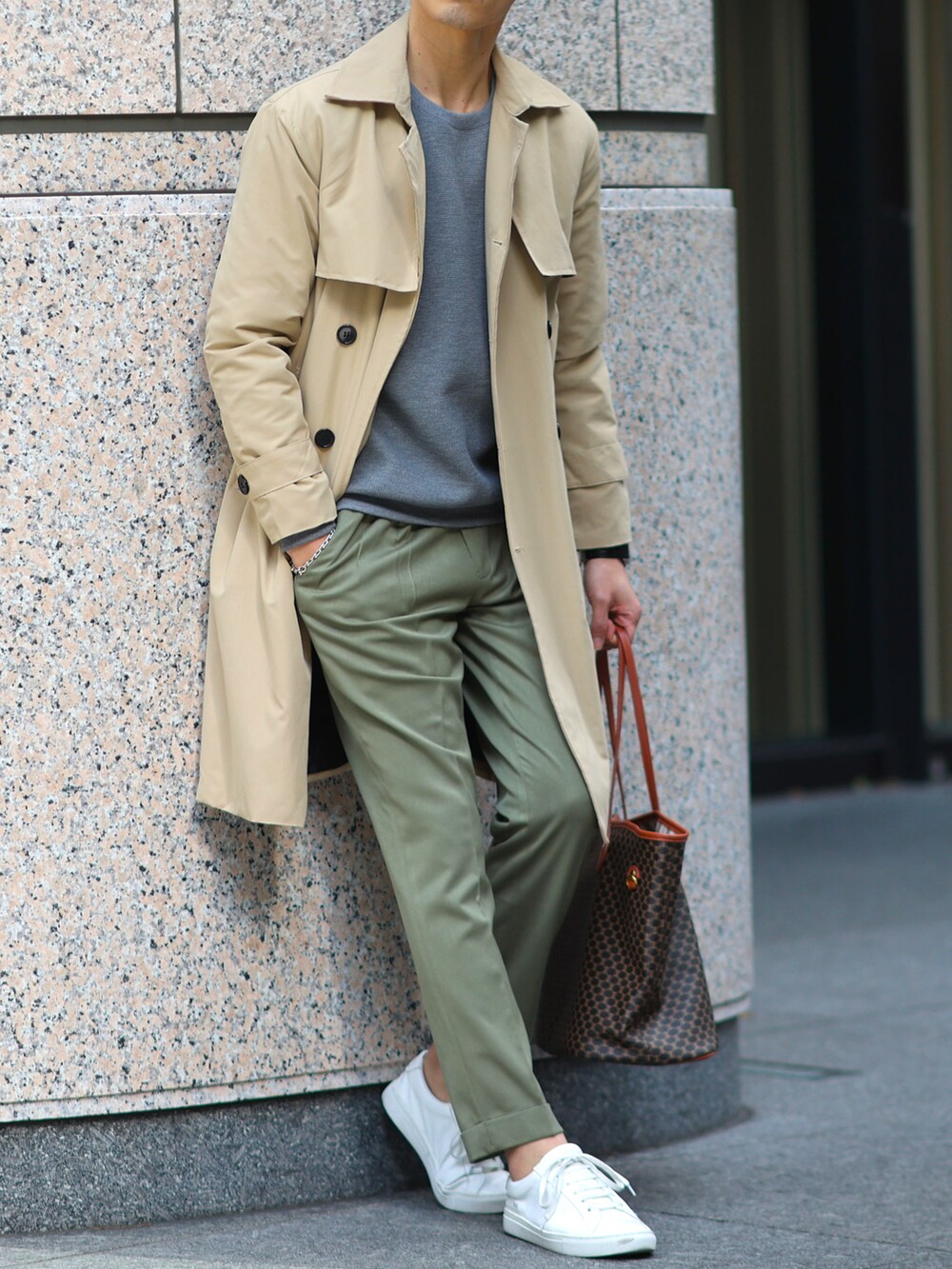 ベージュ系のトレンチコート、グレー系のニット/セーター、グリーン系のスラックスを着用したメンズの冬コーディネートの2枚目の写真