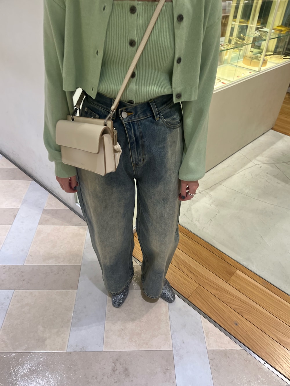 グリーン系のアンサンブル、ブルー系のデニムパンツを着用したレディースの冬コーディネートの3枚目の写真