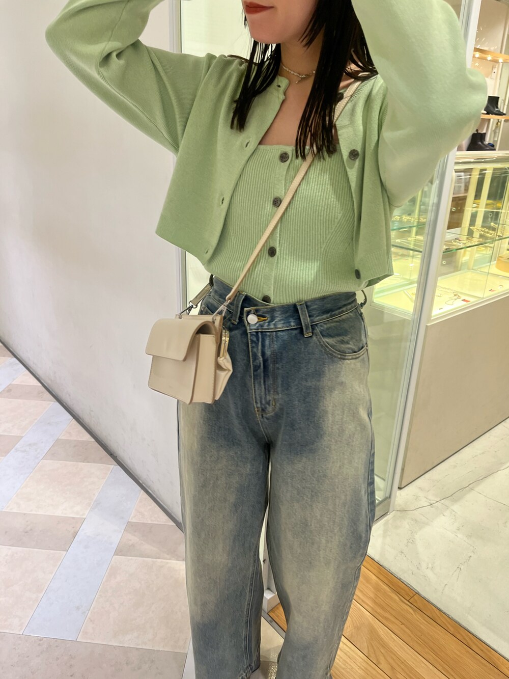 グリーン系のアンサンブル、ブルー系のデニムパンツを着用したレディースの冬コーディネートの2枚目の写真