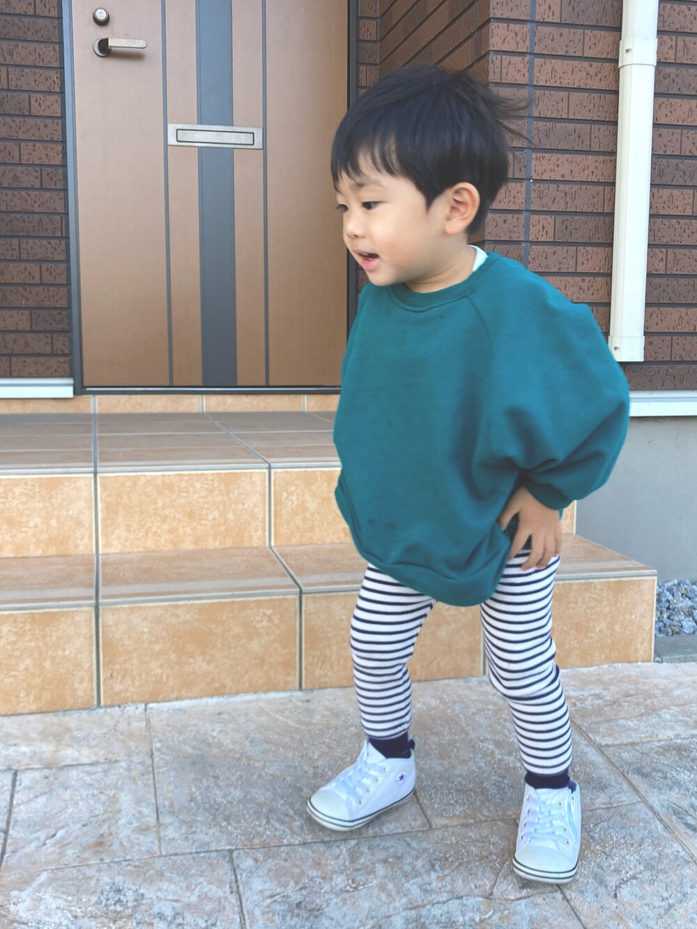 グリーン系のスウェット、その他のパンツ、ホワイト系のスニーカーを着用したキッズの秋コーディネートの2枚目の写真