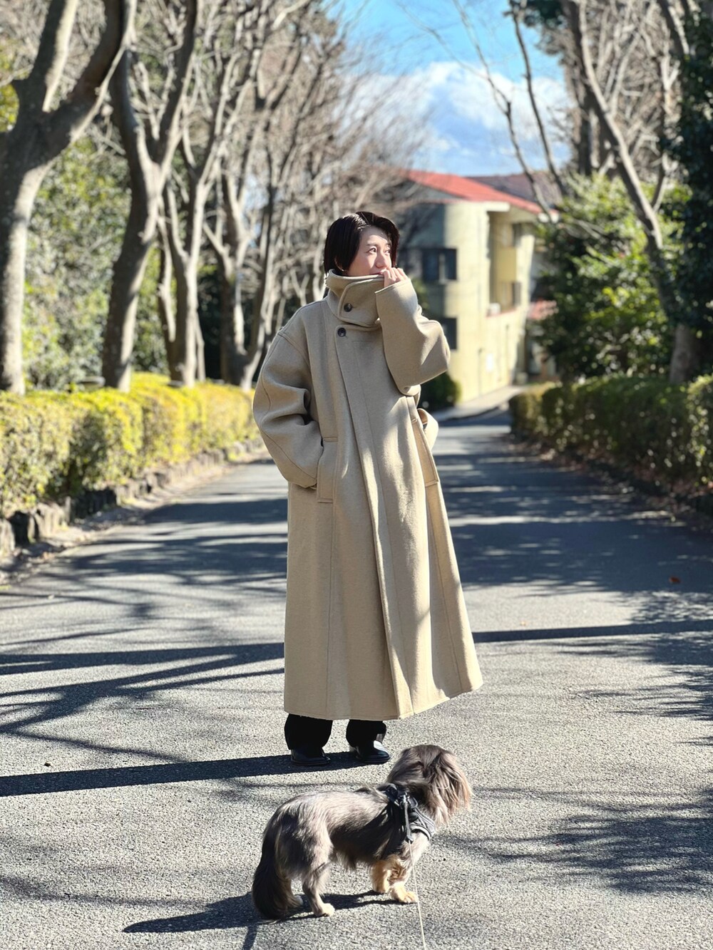 グリーン系のステンカラーコートを着用したレディースの冬コーディネートの2枚目の写真