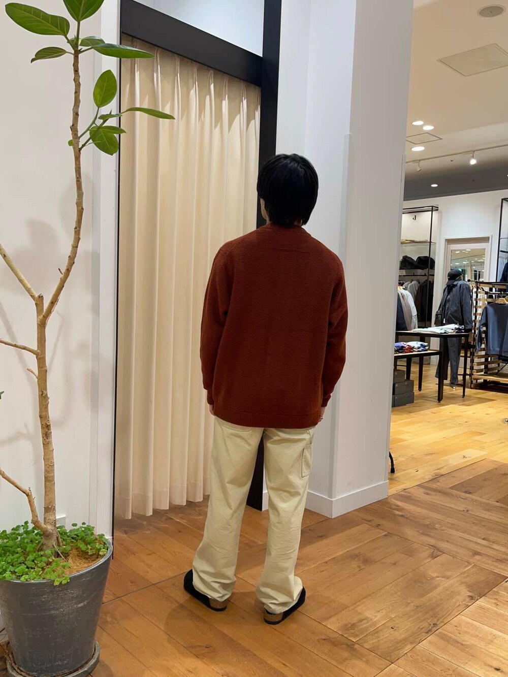 オレンジ系のカーディガン/ボレロ、ベージュ系のその他パンツ、ベージュ系のダウンジャケット/コートを着用したメンズの秋コーディネートの7枚目の写真