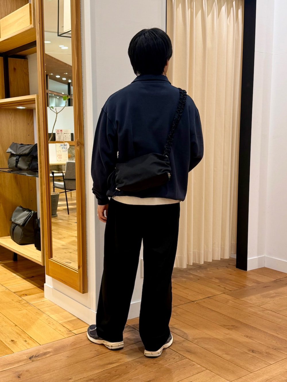 ブルー系のスウェット、ブラック系のショルダーバッグを着用したメンズの春コーディネートの3枚目の写真