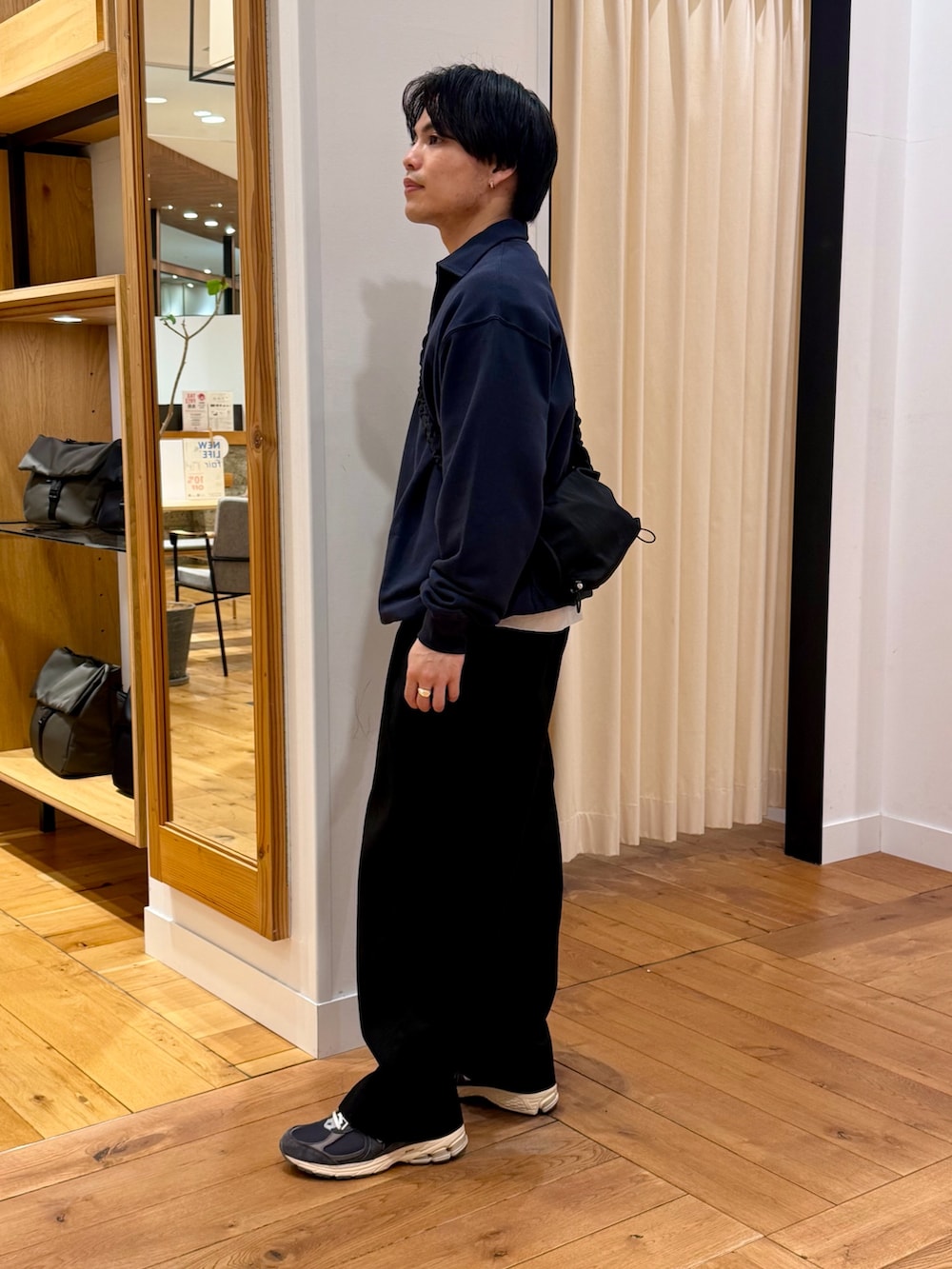 ブルー系のスウェット、ブラック系のショルダーバッグを着用したメンズの春コーディネートの2枚目の写真