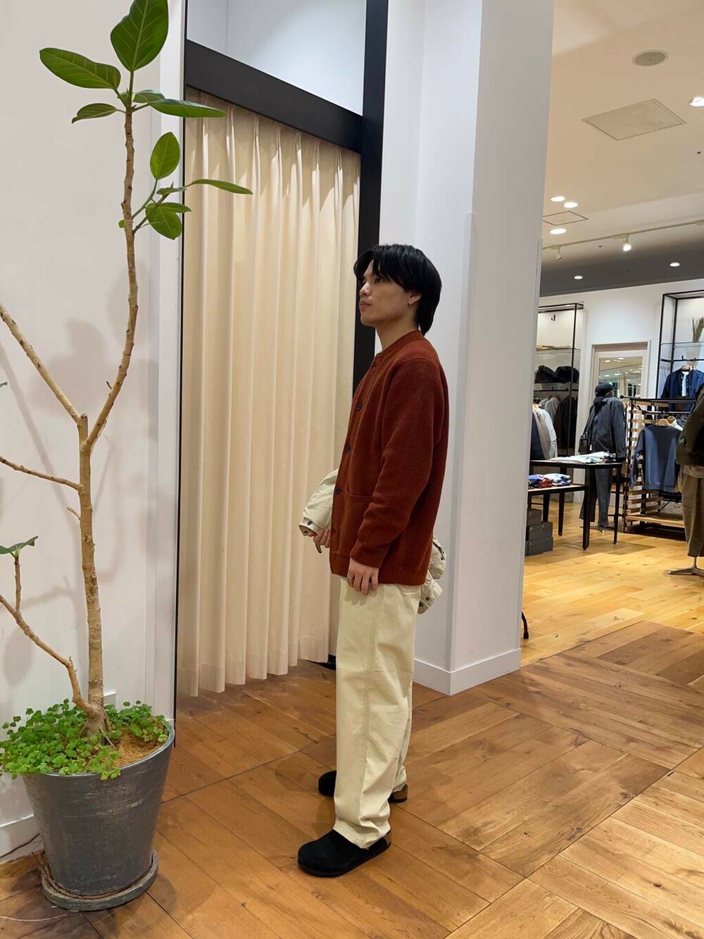 オレンジ系のカーディガン/ボレロ、ベージュ系のその他パンツ、ベージュ系のダウンジャケット/コートを着用したメンズの秋コーディネートの6枚目の写真