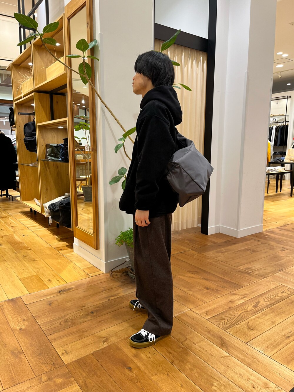 ブラック系のスウェット、ブラック系のスニーカー、ブラック系のその他アウターを着用したメンズの冬コーディネートの2枚目の写真