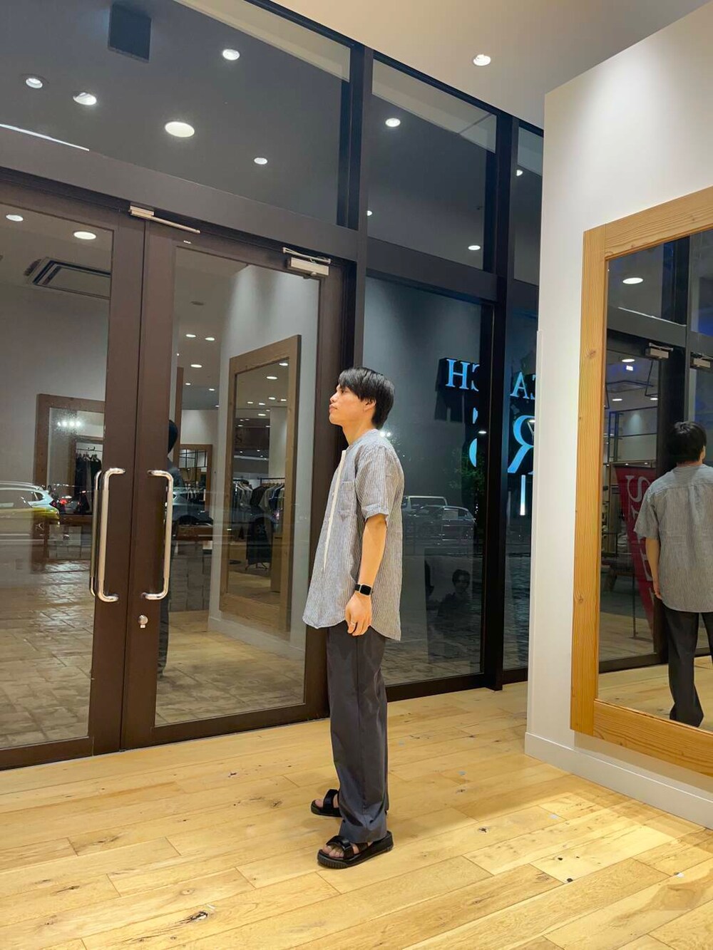 ホワイト系のTシャツ/カットソー、ブルー系のシャツ/ブラウス、ブラック系のサンダルを着用したメンズの夏コーディネートの2枚目の写真