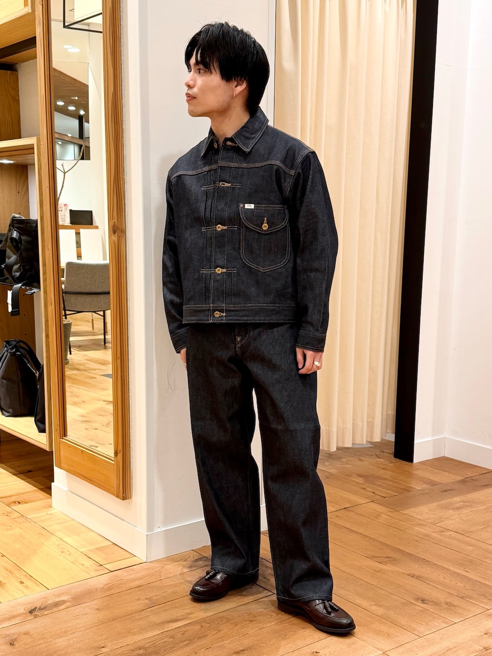 ブルー系のデニムジャケット、ブルー系のデニムパンツ、ブラウン系のドレスシューズを着用したメンズの冬コーディネートの2枚目の写真