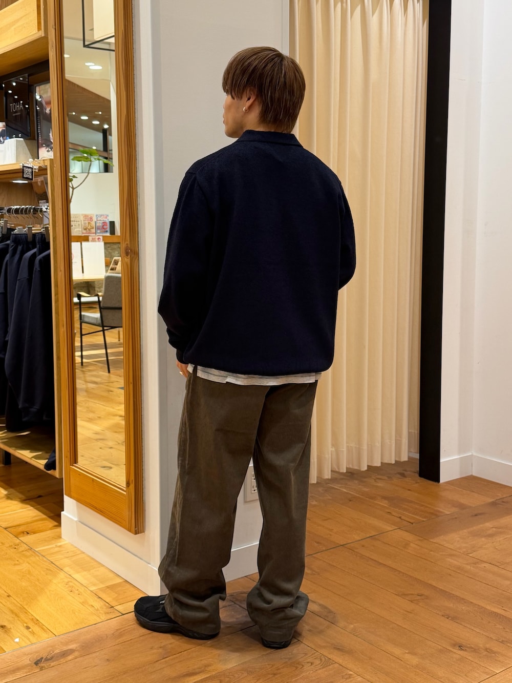ブルー系のニット/セーター、ブラウン系のその他パンツ、ブラック系のスニーカーを着用したメンズの秋コーディネートの3枚目の写真