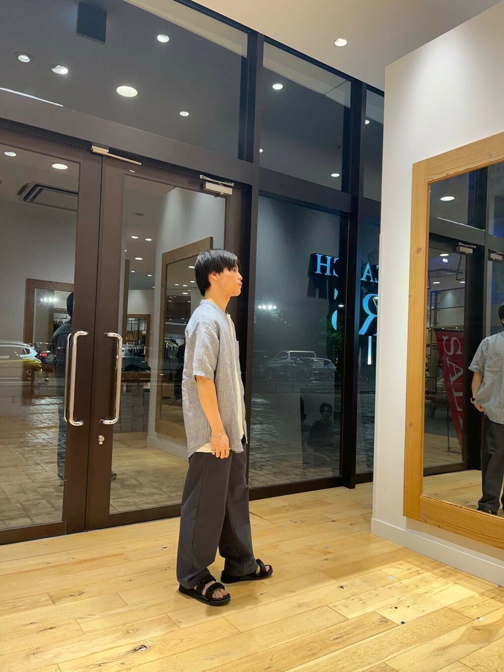 ホワイト系のTシャツ/カットソー、ブルー系のシャツ/ブラウス、ブラック系のサンダルを着用したメンズの夏コーディネートの4枚目の写真