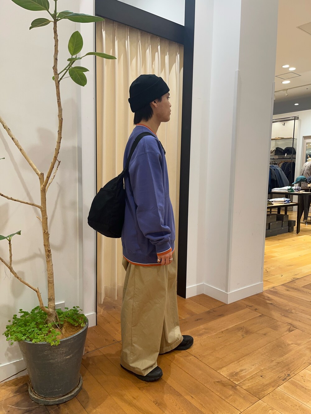 パープル系のスウェット、ブラック系のショルダーバッグ、ブラック系のニットキャップ/ビーニーを着用したメンズの秋コーディネートの4枚目の写真