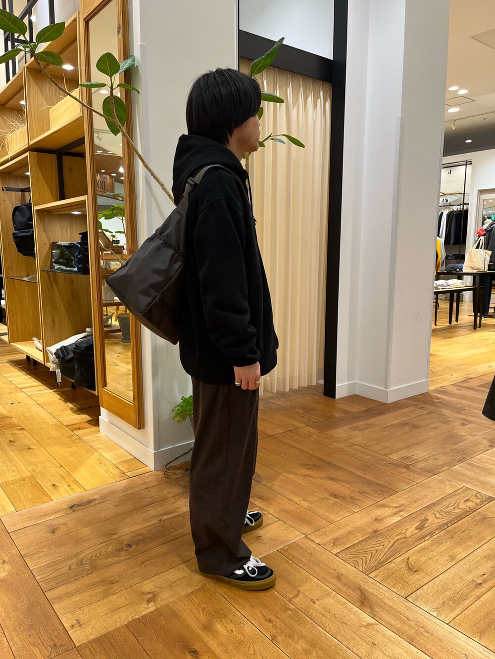 ブラック系のスウェット、ブラック系のスニーカー、ブラック系のその他アウターを着用したメンズの冬コーディネートの3枚目の写真