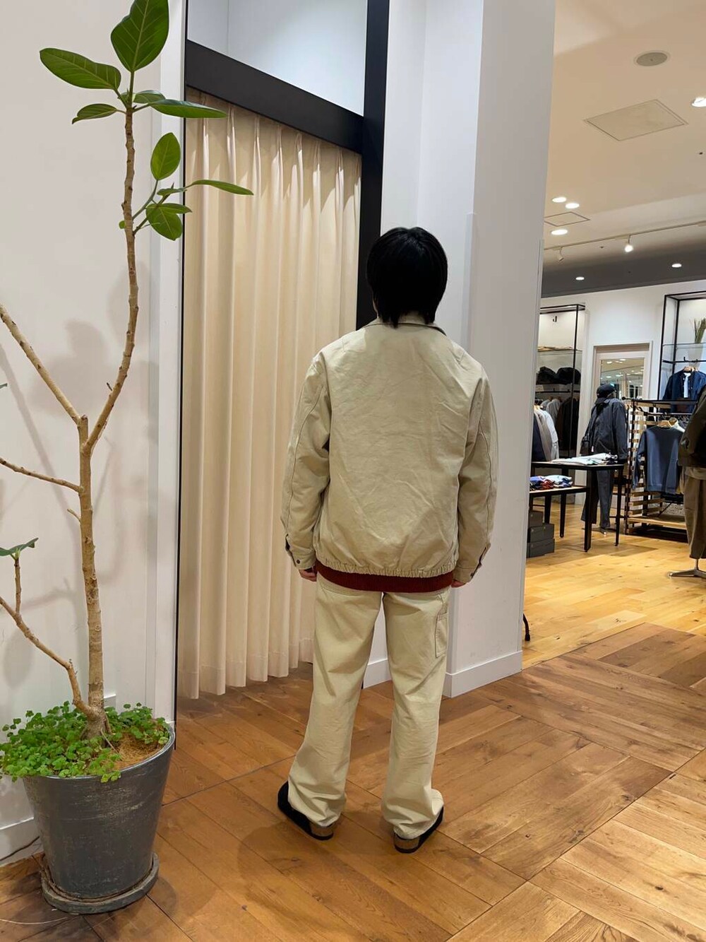 オレンジ系のカーディガン/ボレロ、ベージュ系のその他パンツ、ベージュ系のダウンジャケット/コートを着用したメンズの秋コーディネートの3枚目の写真